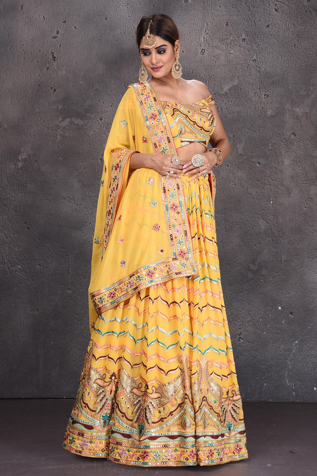 Buy stunning yellow embroidered off-shoulder designer lehenga online in USA with dupatta. Radiate ethnic glam on special occasions in beautiful designer lehengas, Anarkali suits, Indowestern dresses, designer gown, salwar suits from Pure Elegance Indian fashion store in USA,-side