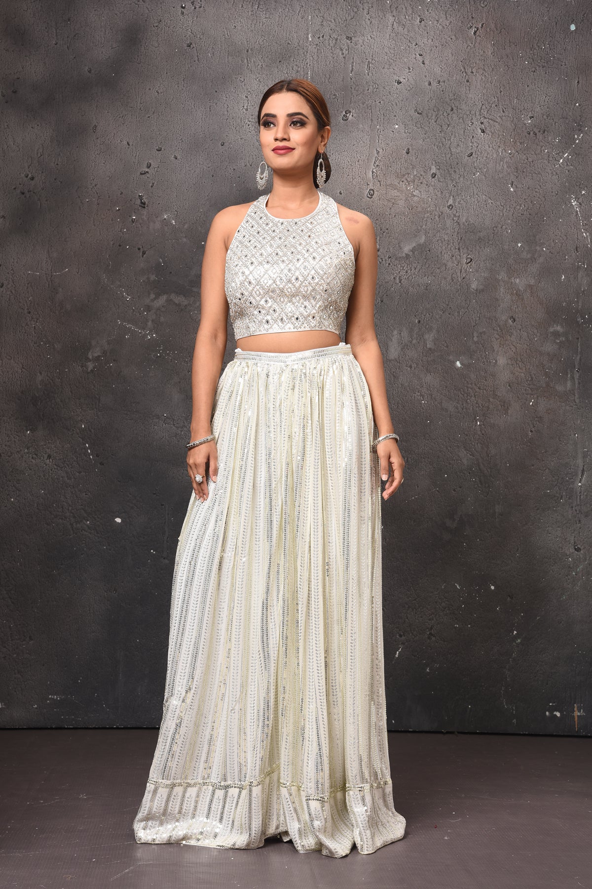 Buy beautiful off-white embellished halter neck top online in USA with skirt. Get set for weddings and festive occasions in exclusive designer Anarkali suits, wedding gown, salwar suits, gharara suits, Indowestern dresses from Pure Elegance Indian fashion store in USA.-front