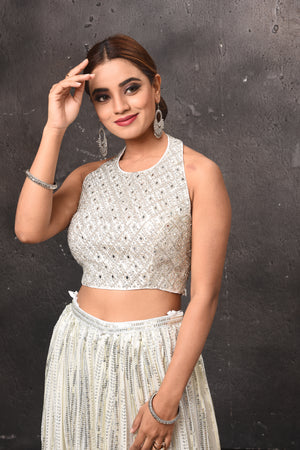 Buy beautiful off-white embellished halter neck top online in USA with skirt. Get set for weddings and festive occasions in exclusive designer Anarkali suits, wedding gown, salwar suits, gharara suits, Indowestern dresses from Pure Elegance Indian fashion store in USA.-closeup
