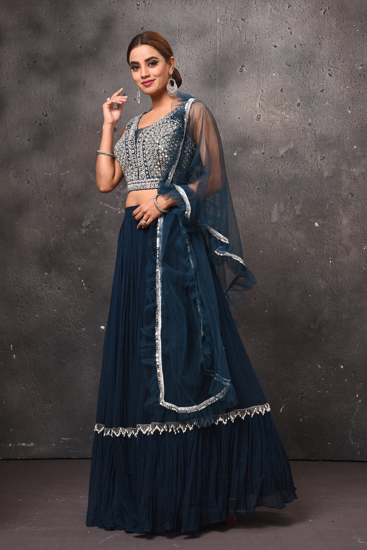 Shop stunning dark blue designer lehenga online in USA with ruffle dupatta. Get set for weddings and festive occasions in exclusive designer Anarkali suits, wedding gown, salwar suits, gharara suits, Indowestern dresses from Pure Elegance Indian fashion store in USA.-side