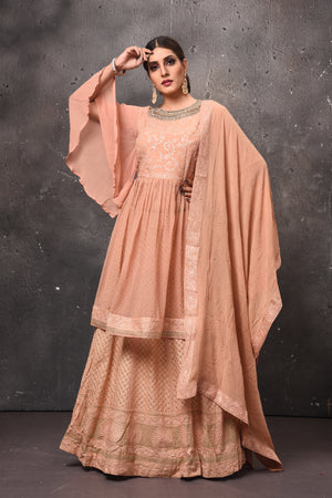 Buy beautiful peach peplum sharara suit online in USA with dupatta. Get set for weddings and festive occasions in exclusive designer Anarkali suits, wedding gown, salwar suits, gharara suits, Indowestern dresses from Pure Elegance Indian fashion store in USA.-front
