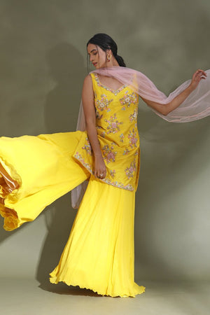 Shop stunning bright yellow embroidered sharara suit online in USA with powder pink dupatta. Look your best at weddings and parties in Indian dresses, designer lehengas, Anarkali suits, designer gowns, salwar suits, sharara suits from Pure Elegance Indian fashion store in USA.-sharara