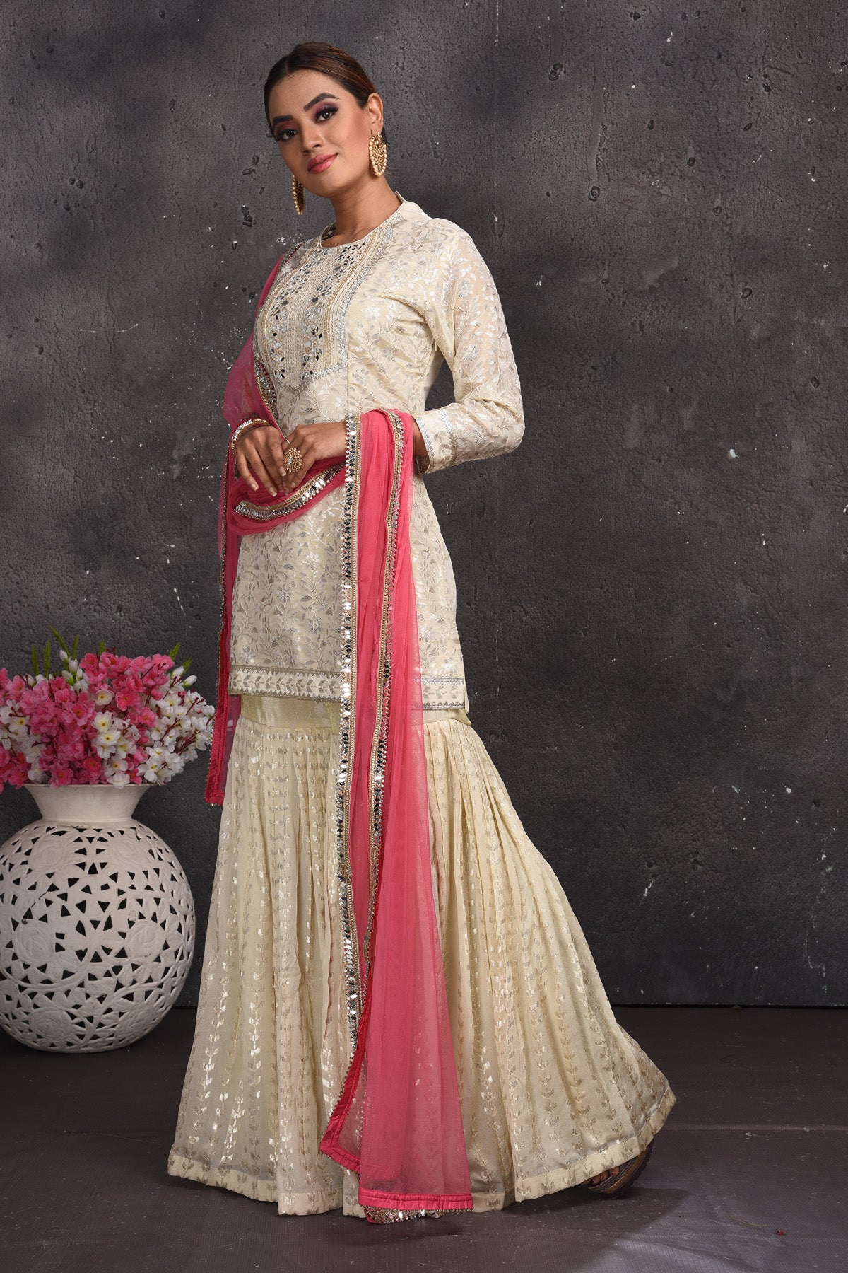 Shop beautiful off-white embroidered gharara suit online in USA with pink dupatta. Look your best at weddings and special occasions in exclusive designer lehengas, Anarkali suits, sharara suits. designer gowns and Indian dresses from Pure Elegance Indian fashion store in USA.-side