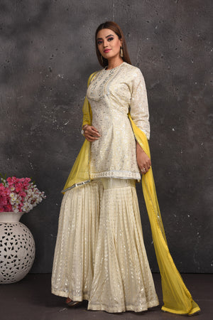 Shop gorgeous off-white embroidered gharara suit online in USA with yellow dupatta. Look your best at weddings and special occasions in exclusive designer lehengas, Anarkali suits, sharara suits. designer gowns and Indian dresses from Pure Elegance Indian fashion store in USA.-side