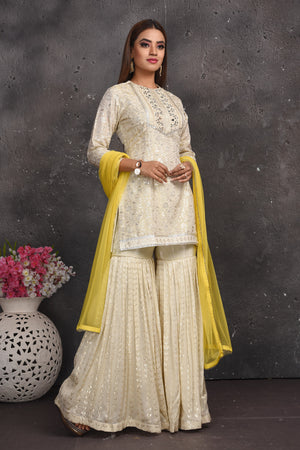 Shop gorgeous off-white embroidered gharara suit online in USA with yellow dupatta. Look your best at weddings and special occasions in exclusive designer lehengas, Anarkali suits, sharara suits. designer gowns and Indian dresses from Pure Elegance Indian fashion store in USA.-front
