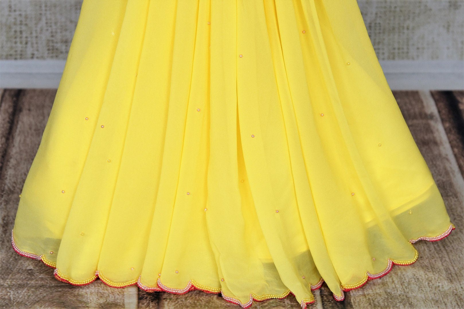 Buy beautiful lemon yellow embroidered georgette saree online in USA with pink embroidered blouse. Look your best at weddings and parties in Indian sarees, designer saris, printed sarees, embroidered sarees from Pure Elegance Indian fashion store in USA.-pleats
