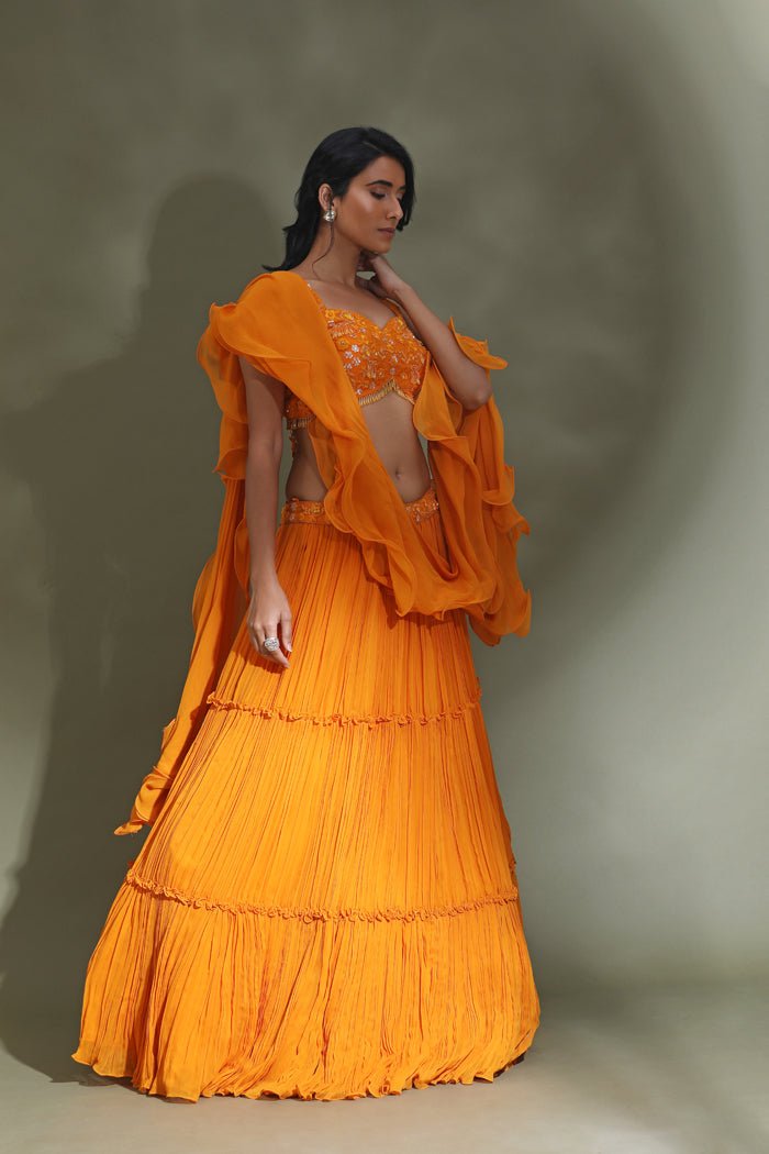 Buy stunning orange tiered lehenga online in USA with ruffle dupatta. Look your best at weddings and parties in Indian dresses, designer lehengas, Anarkali suits, designer gowns, salwar suits, sharara suits from Pure Elegance Indian fashion store in USA.-side