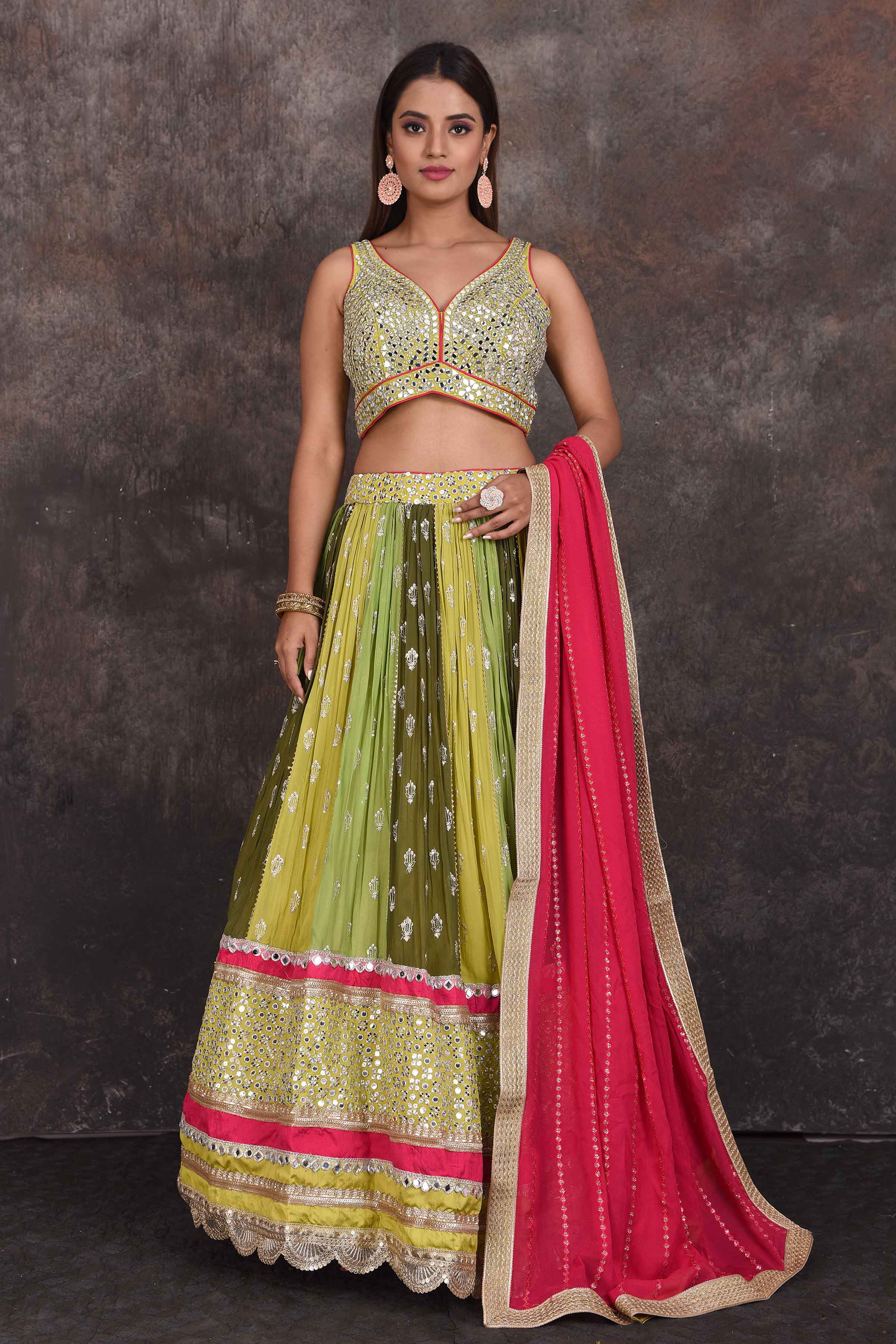 Buy beautiful green and yellow mirror work lehenga online in USA with pink dupatta. Be the star of the occasion in this stylish designer lehengas, designer gowns, Indowestern dresses, Anarkali suits, sharara suits from Pure Elegance Indian fashion store in USA.-front