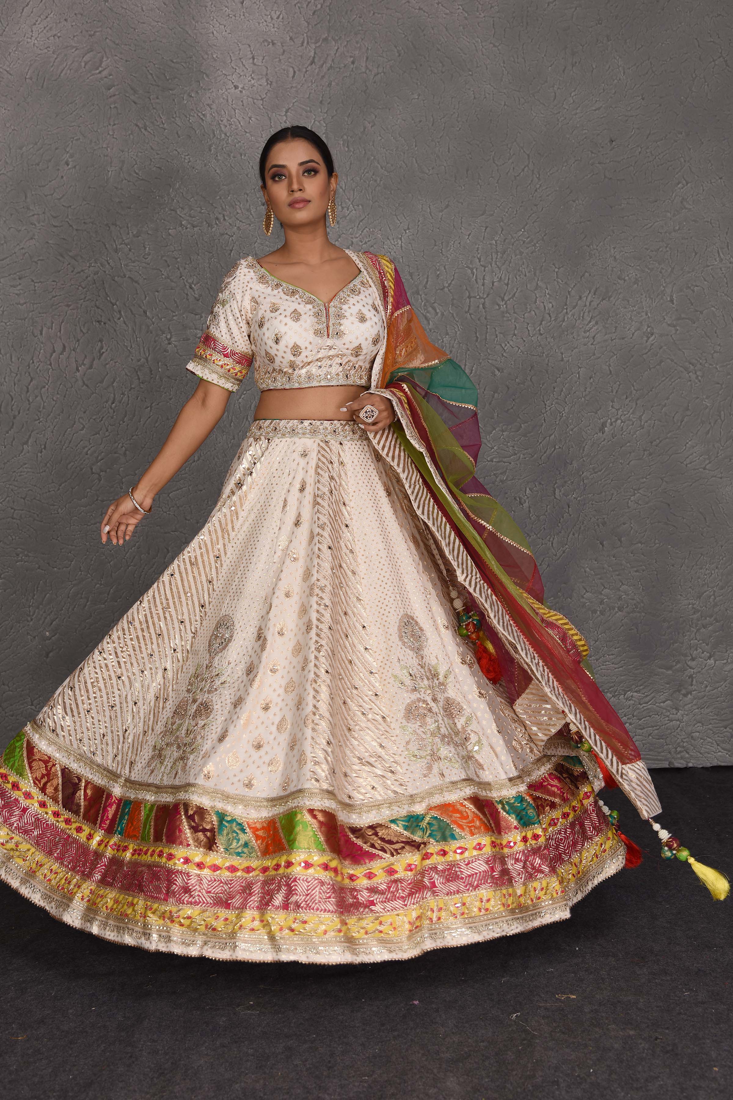 Buy cream embroidered lehenga online in USA with multicolor border. Flaunt your Indian style on festive occasions in stunning designer lehengas, Anarkali suit, sharara suits, designer gowns, designer sarees, embroidered sarees from Pure Elegance India fashion store in USA. -front