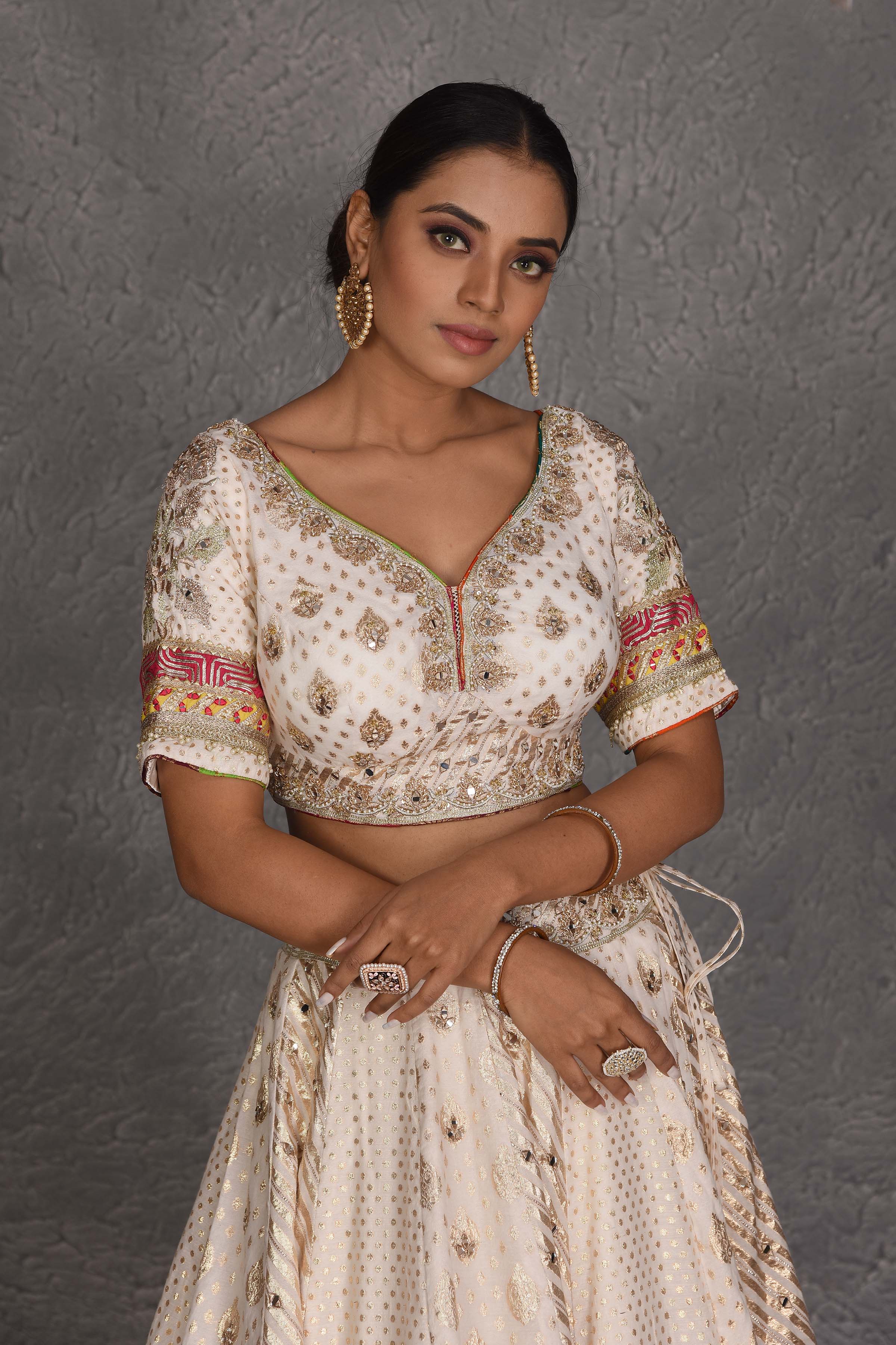 Buy cream embroidered lehenga online in USA with multicolor border. Flaunt your Indian style on festive occasions in stunning designer lehengas, Anarkali suit, sharara suits, designer gowns, designer sarees, embroidered sarees from Pure Elegance India fashion store in USA. -closeup
