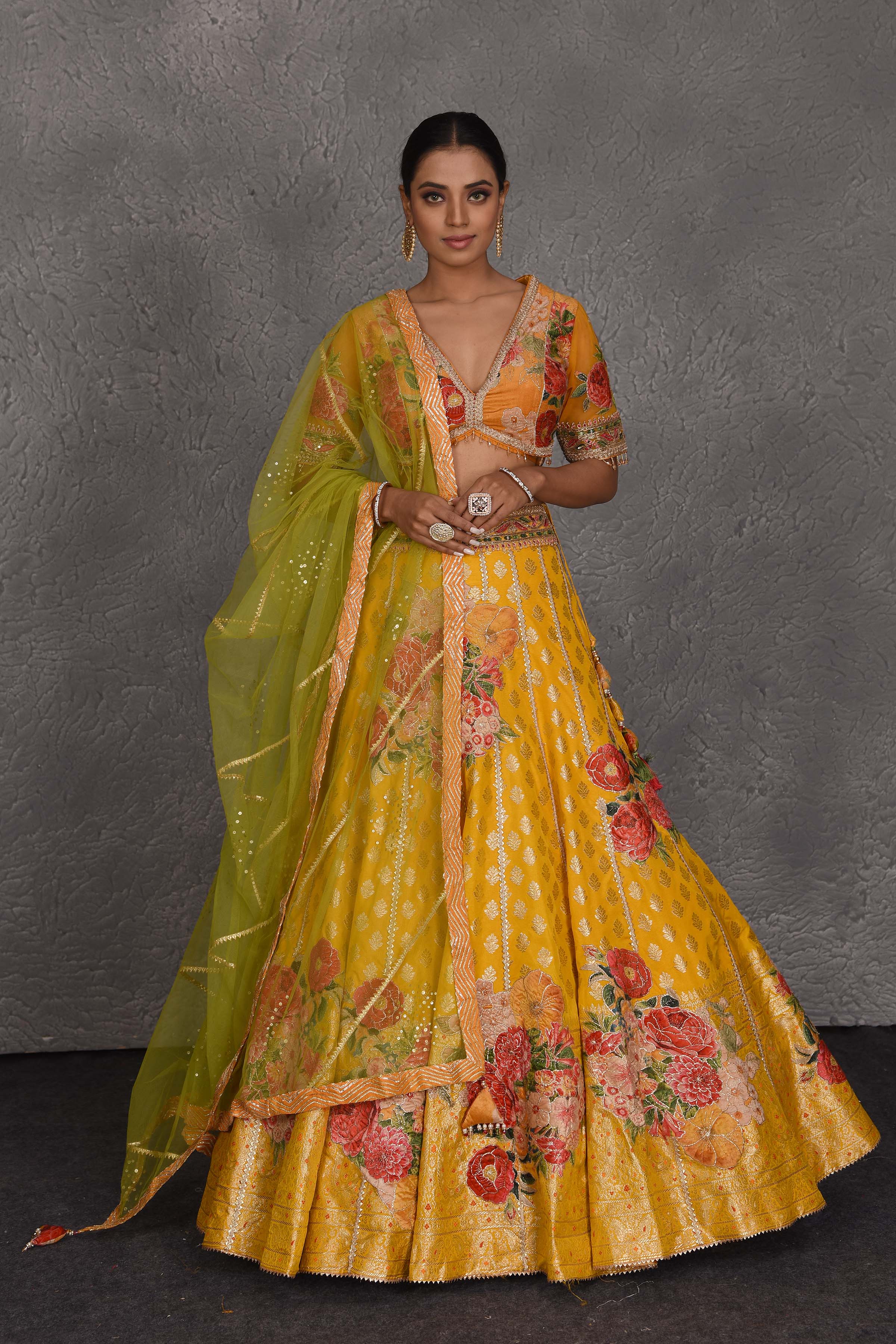 Shop yellow Banarasi floral lehenga online in USA with green net dupatta. Flaunt your Indian style on festive occasions in stunning designer lehengas, Anarkali suit, sharara suits, designer gowns, designer sarees, embroidered sarees from Pure Elegance India fashion store in USA. -full view