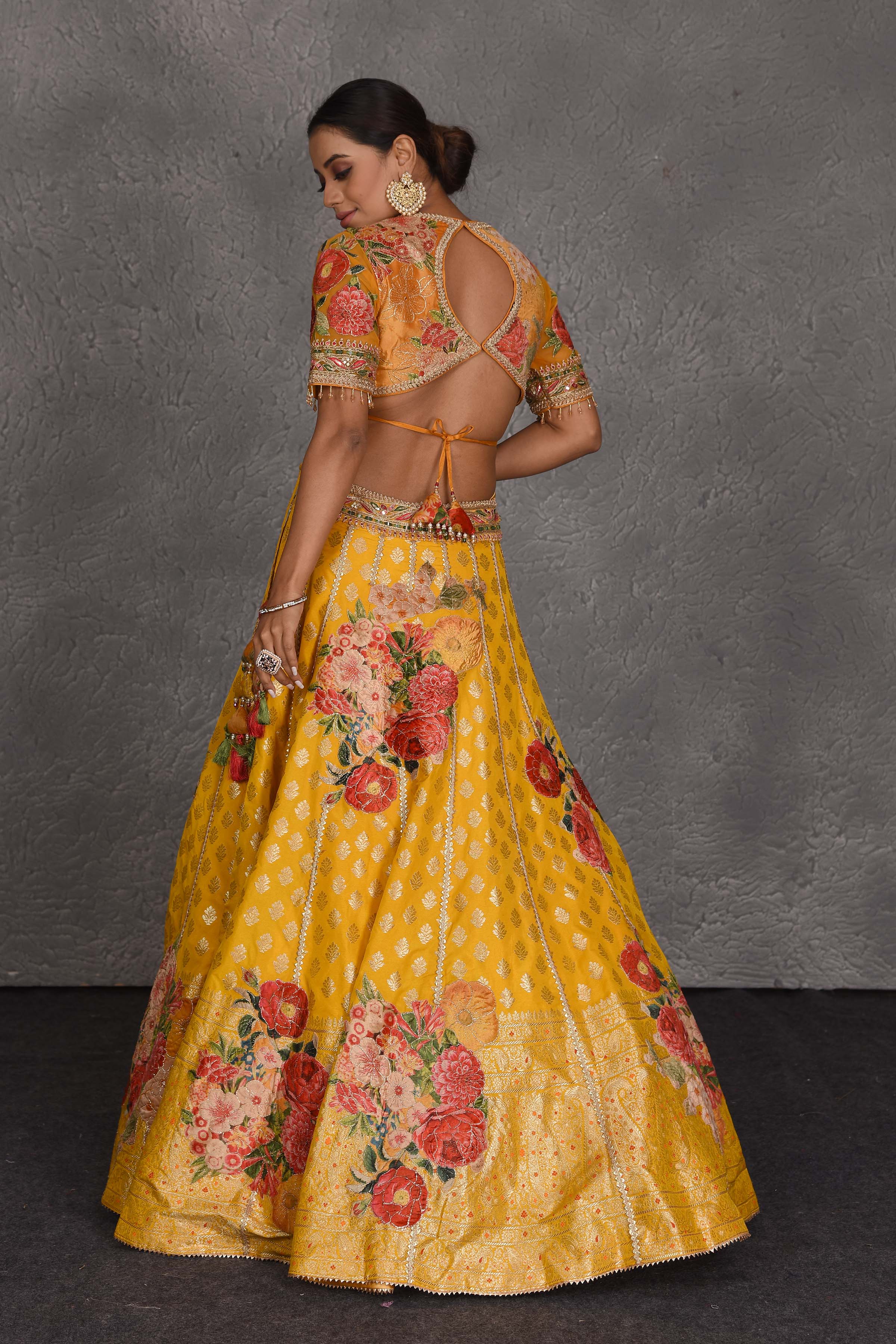 Shop yellow Banarasi floral lehenga online in USA with green net dupatta. Flaunt your Indian style on festive occasions in stunning designer lehengas, Anarkali suit, sharara suits, designer gowns, designer sarees, embroidered sarees from Pure Elegance India fashion store in USA. -back
