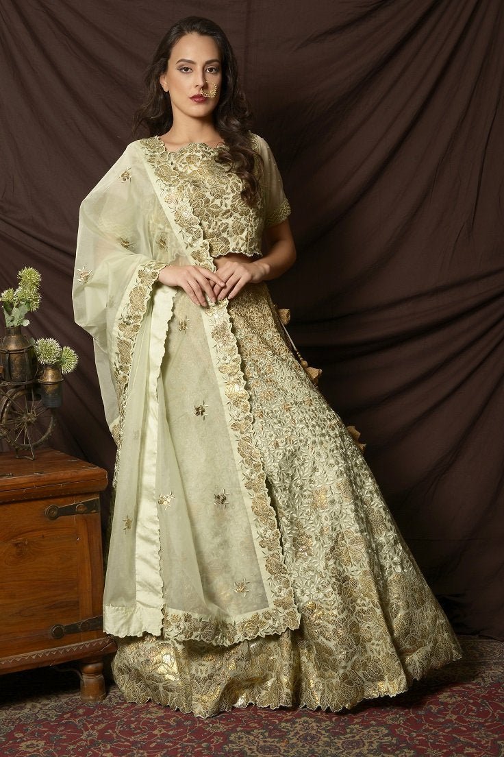 Buy gorgeous dusty green foil print embroidered lehenga online in USA with dupatta. Shine at weddings and special occasions with beautiful Indian designer dresses, gowns, lehengas from Pure Elegance Indian clothing store in USA.-side
