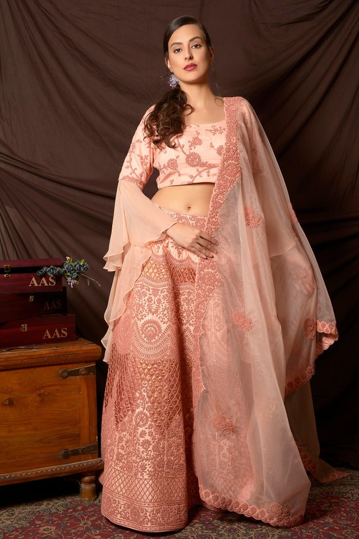 Shop lovely peach color embroidered silk lehenga online in USA with dupatta. Shine at weddings and special occasions with beautiful Indian designer dresses, gowns, lehengas from Pure Elegance Indian clothing store in USA.-frontlook