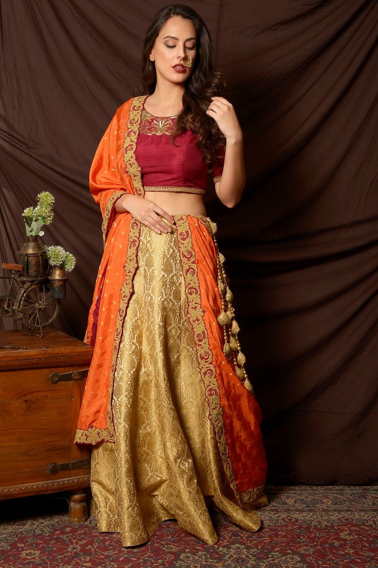 Buy gorgeous maroon and green embroidered brocade lehenga online in USA with orange dupatta. Shine at weddings and special occasions with beautiful Indian designer dresses, gowns, lehengas from Pure Elegance Indian clothing store in USA.-full view