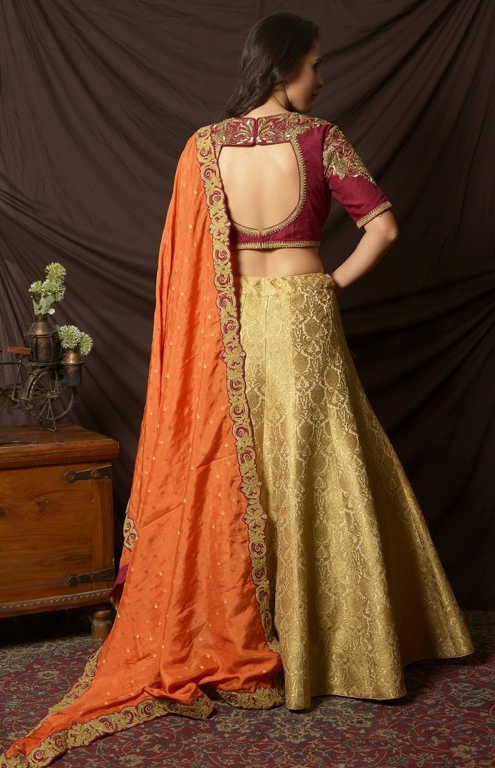 Buy gorgeous maroon and green embroidered brocade lehenga online in USA with orange dupatta. Shine at weddings and special occasions with beautiful Indian designer dresses, gowns, lehengas from Pure Elegance Indian clothing store in USA.-back