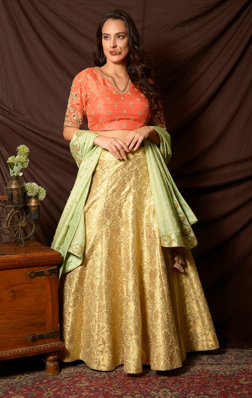 Shop gorgeous peach and gold embroidered brocade lehenga online in USA with pista green dupatta. Shine at weddings and special occasions with beautiful Indian designer dresses, gowns, lehengas from Pure Elegance Indian clothing store in USA.-lehenga