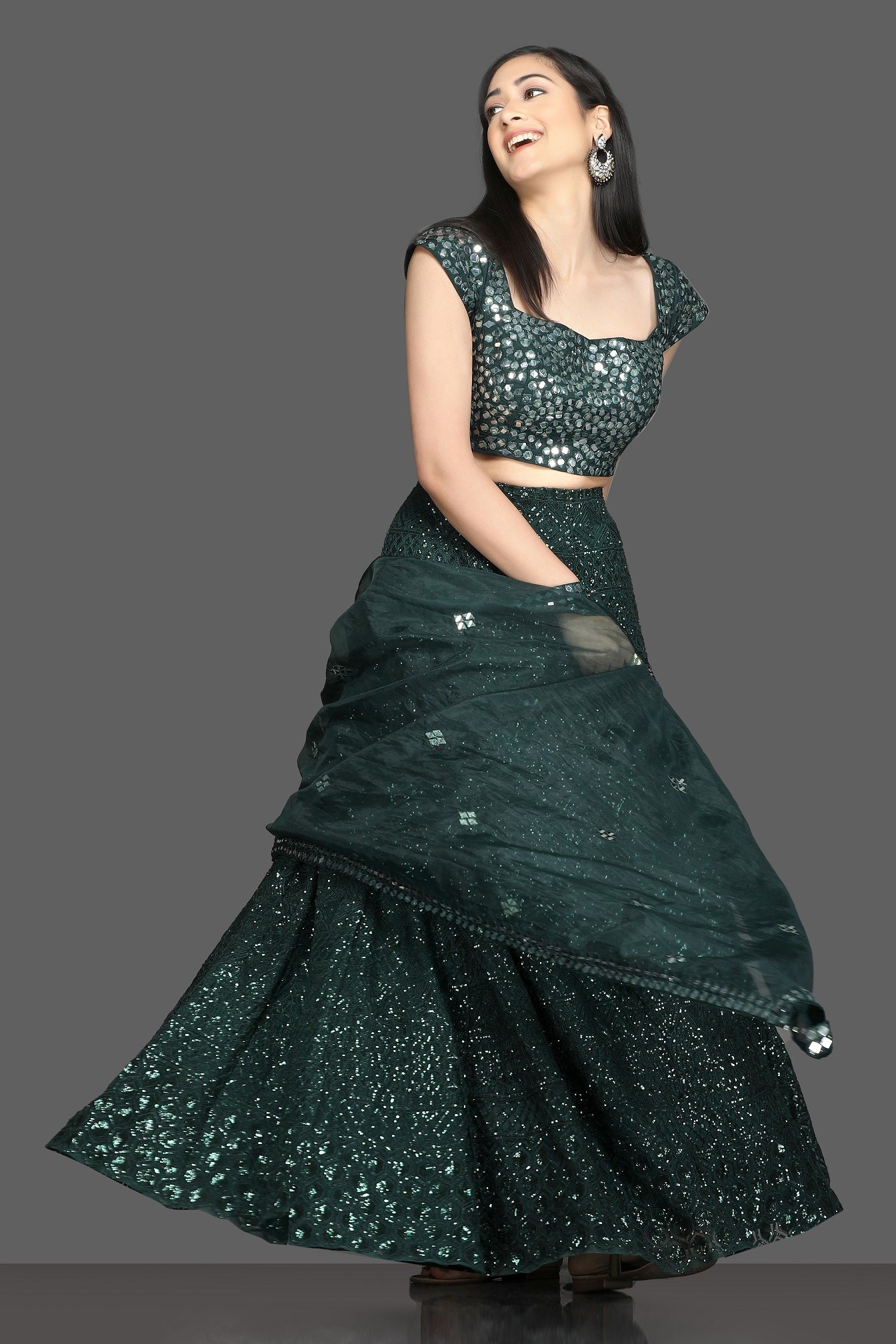 Shop stunning dark green mirror work lehenga online in USA with net dupatta. Dazzle on weddings and special occasions with exquisite Indian designer dresses, sharara suits, Anarkali suits, bridal lehegas from Pure Elegance Indian fashion store in USA.-front