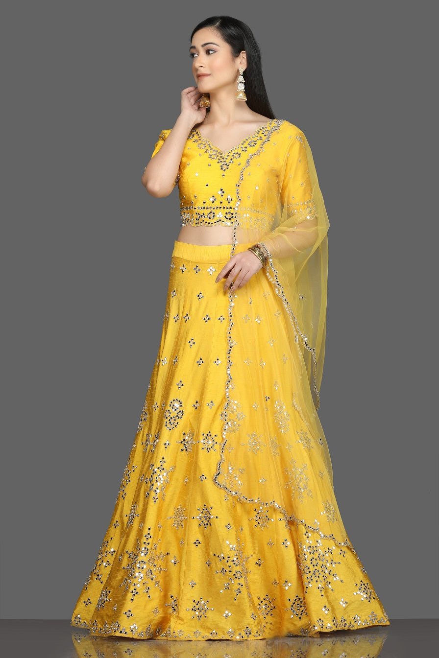 Shop gorgeous bright yellow mirror work lehenga online in USA with net dupatta. Dazzle on weddings and special occasions with exquisite Indian designer dresses, sharara suits, Anarkali suits, bridal lehegas from Pure Elegance Indian fashion store in USA.-full view