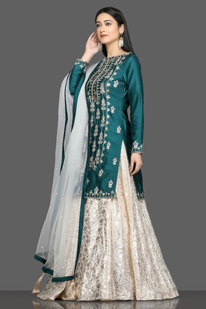 Buy stunning green and white embroidered lehenga online in USA with net dupatta. Dazzle on weddings and special occasions with exquisite Indian designer dresses, sharara suits, Anarkali suits, bridal lehengas from Pure Elegance Indian fashion store in USA.-left