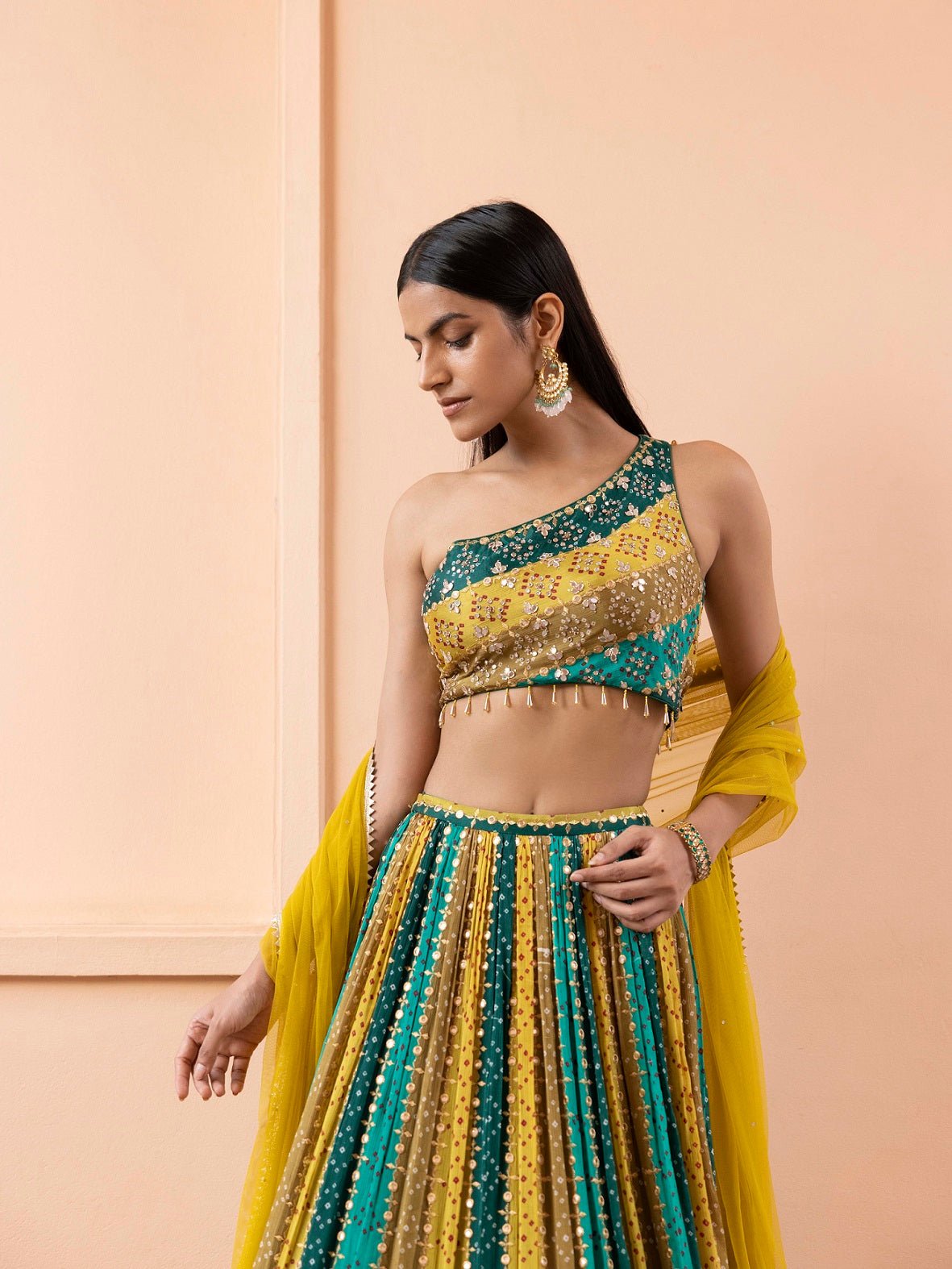 Shop beautiful green and mustard sripes bandhej one shoulder lehenga online in USA with dupatta. Dazzle on weddings and special occasions with exquisite Indian designer dresses, sharara suits, Anarkali suits, wedding lehengas from Pure Elegance Indian fashion store in USA.-blouse