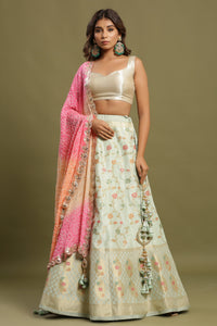 Shop a Beautiful light blue silk lehenga with a multicolor dupatta. The lehenga is perfect for weddings and sangeet parties. It is crafted in silk with intrinsic floral self-design work, tassels, and a beautiful off-white blouse. Shop online from Pure Elegance.