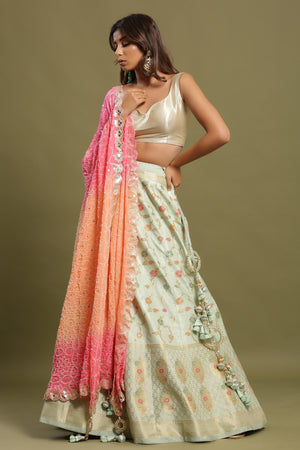 Shop a Beautiful light blue silk lehenga with a multicolor dupatta. The lehenga is perfect for weddings and sangeet parties. It is crafted in silk with intrinsic floral self-design work, tassels, and a beautiful off-white blouse. Shop online from Pure Elegance.