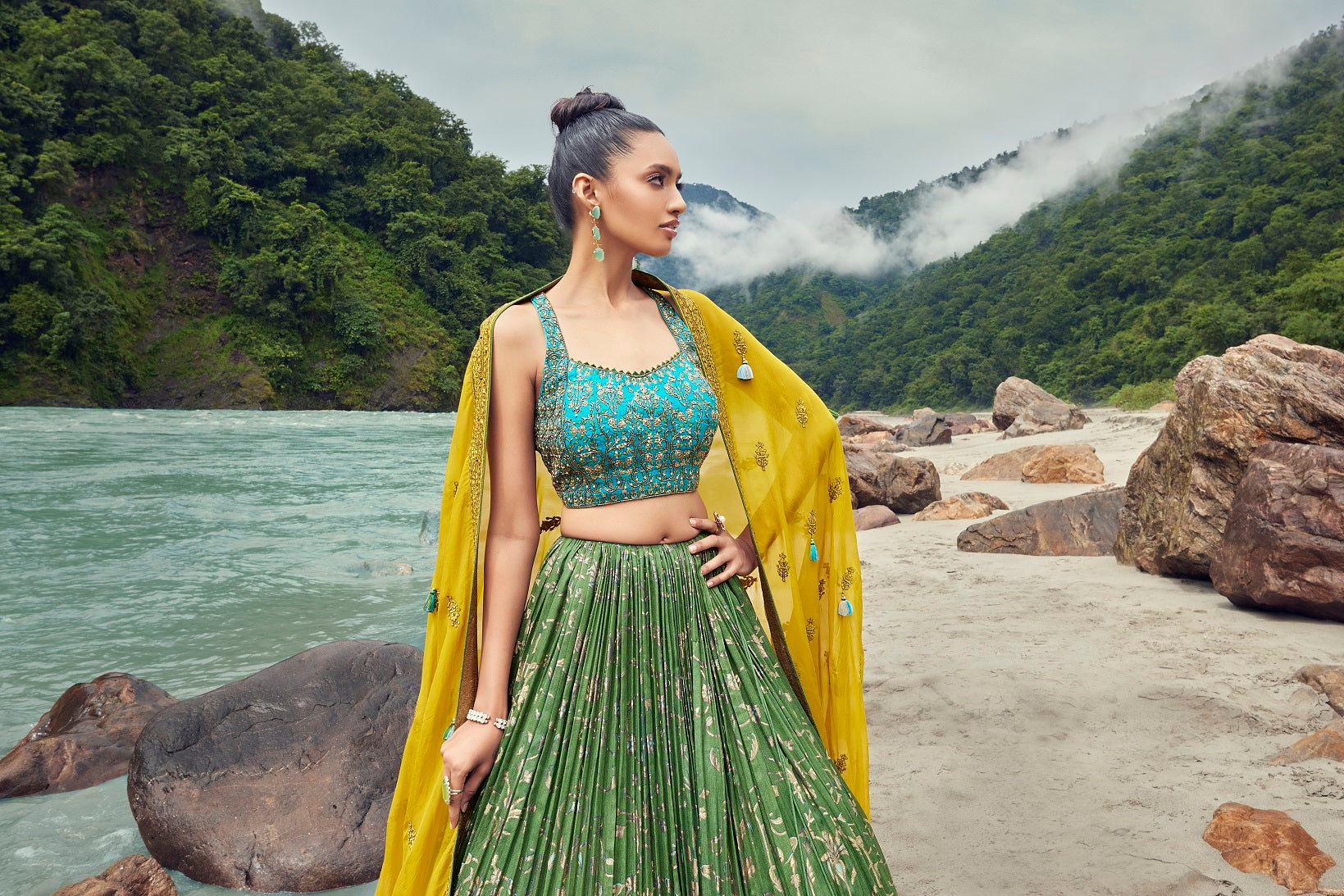 Shop this beautiful green blue lehenga with an embellished yellow dupatta. The lehenga is perfect for haldi and sangeet parties. It is crafted with intricate embroidery work. Shop online from Pure Elegance.