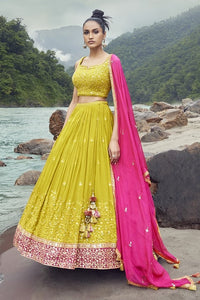 Shop exquisite yellow lehenga with pink dupatta. The lehenga is perfect for haldi and sangeet parties. It is crafted in silk with beautiful embroidery, cut dana, and a sleeveless blouse. Shop online from Pure Elegance.