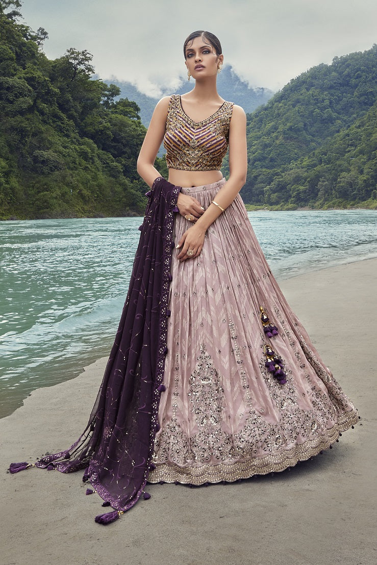 Shop exquisite mauve lehenga with wine georgette dupatta. The lehenga is perfect for cocktail and wedding parties. It is crafted in georgette with beautiful embroidery, cut dana, and a sleeveless blouse. Shop online from Pure Elegance.