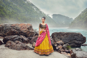 Shop an exquisite yellow lehenga with a pink georgette dupatta. The lehenga is perfect for haldi and sangeet parties. It is crafted in georgette with beautiful embroidery, cut dana, and an embroidered blouse. Shop online from Pure Elegance.