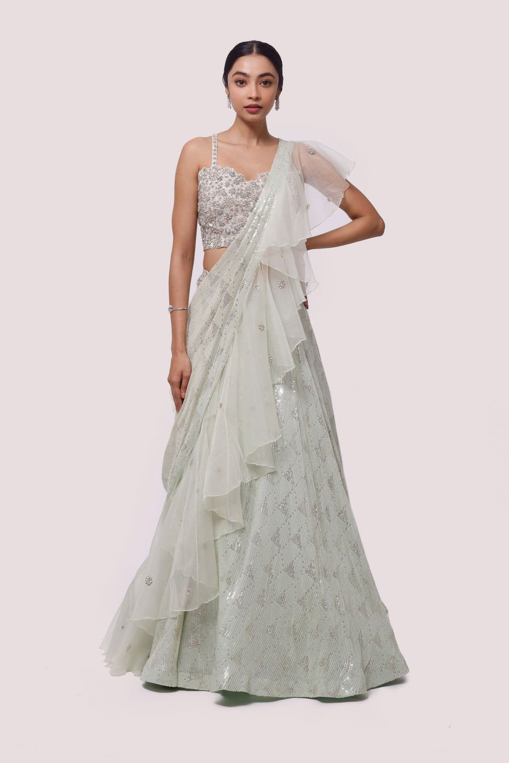 Shop the look your best on wedding occasions in this green lehenga with elaborate silver cut dana, sequence work, and a ruffle beautiful dupatta. Dazzle on weddings and special occasions with exquisite Indian designer dresses, sharara suits, Anarkali suits, bridal lehengas, and sharara suits from Pure Elegance Indian clothing store in the USA. Shop online from Pure Elegance.