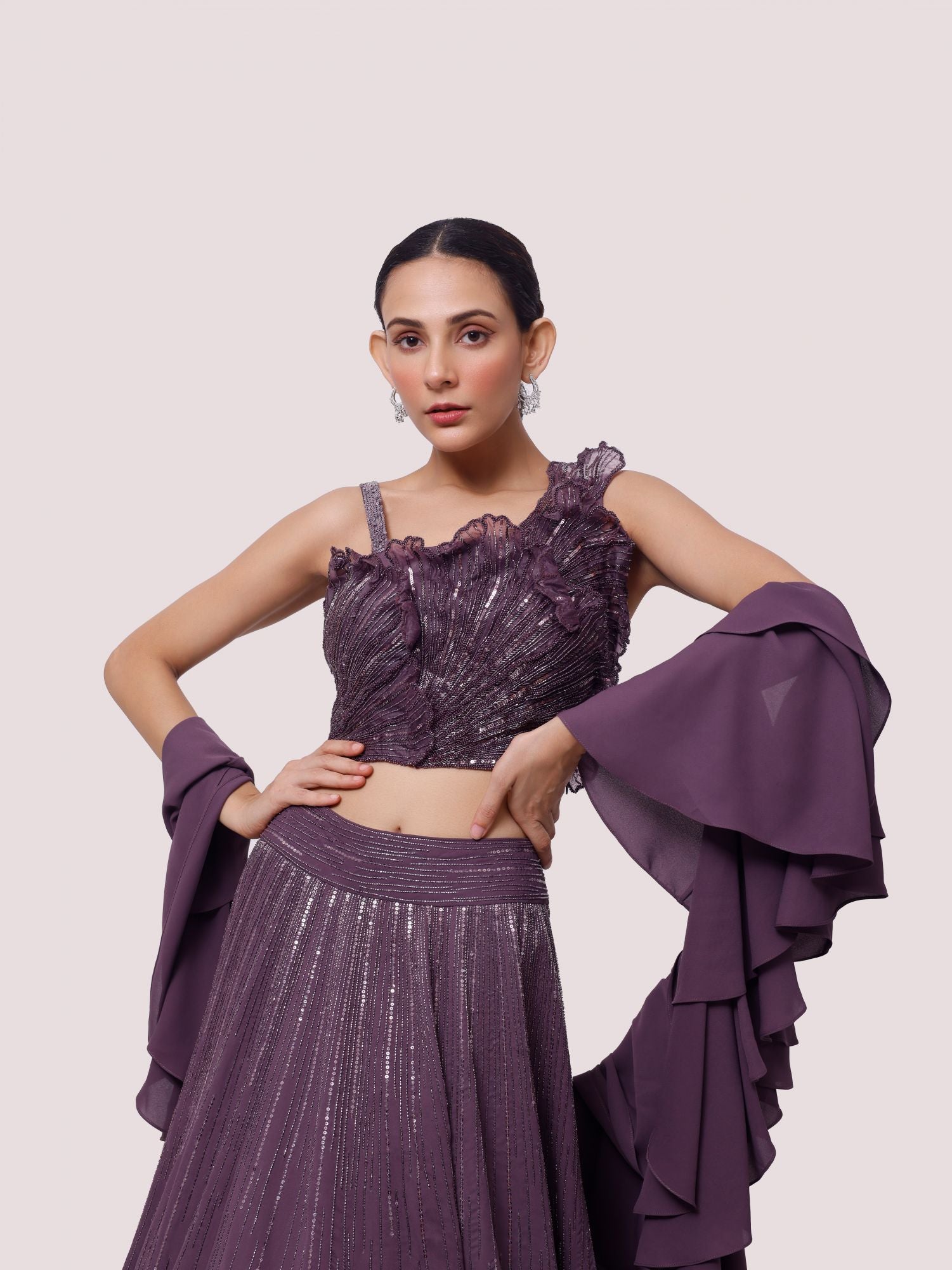 Buy a Beautiful purple georgette sleeveless lehenga featuring pearl, cut dana, and sequin work. The lehenga is perfect for weddings and sangeet parties. Shop online from Pure Elegance.