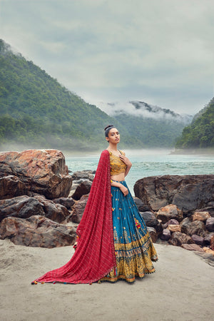 Shop an exquisite blue lehenga with a red dupatta. The lehenga is perfect for weddings and sangeet parties. It is crafted in georgette with beautiful embroidery and a sleeveless yellow blouse. Shop online from Pure Elegance.