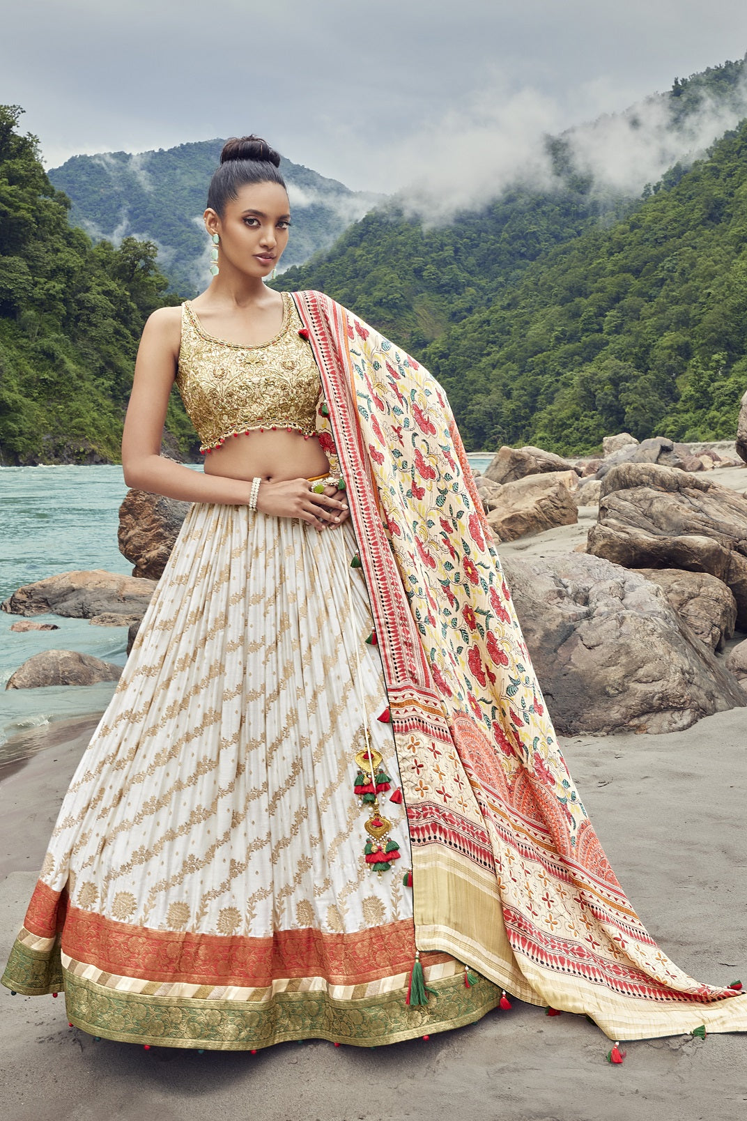 Shop an exquisite white lehenga with a floral dupatta. The lehenga is perfect for weddings and sangeet parties. It is crafted in georgette with beautiful embroidery and a sleeveless blouse. Shop online from Pure Elegance.