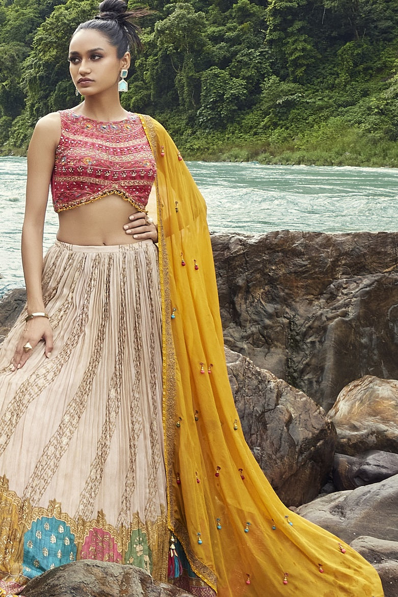 Shop this beautiful off-white lehenga with an embellished yellow dupatta. The lehenga is perfect for haldi parties. It is crafted with intricate embroidery work. Shop online from Pure Elegance.