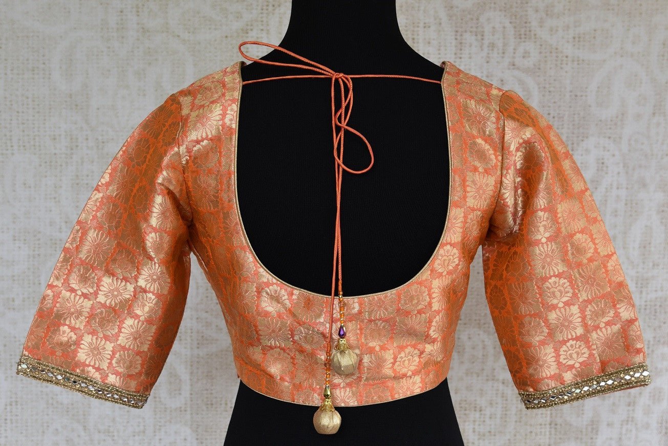 Shop this Indian ethnic orange blouse having stone work on neck and sleeves online or from our store in USA. It is perfect for any engagement or wedding party.  Round Back.