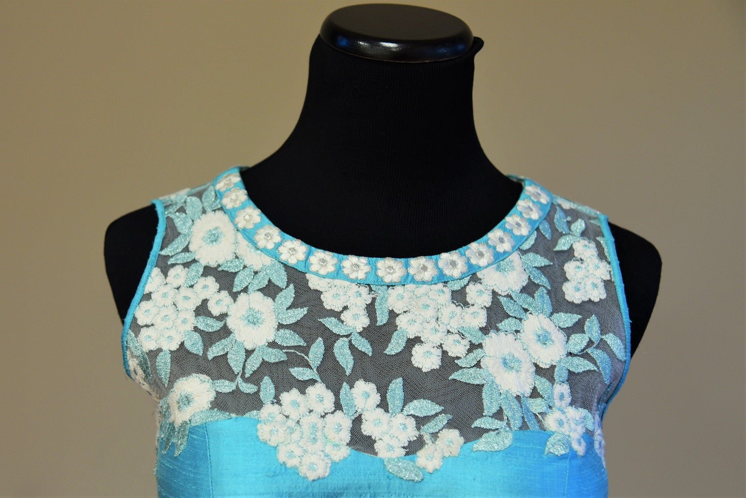 Shop this traditional Indian turquoise blue raw silk blouse having lace embroidery online or our Pure Elegance store in USA. Perfect for any reception party. Close up.