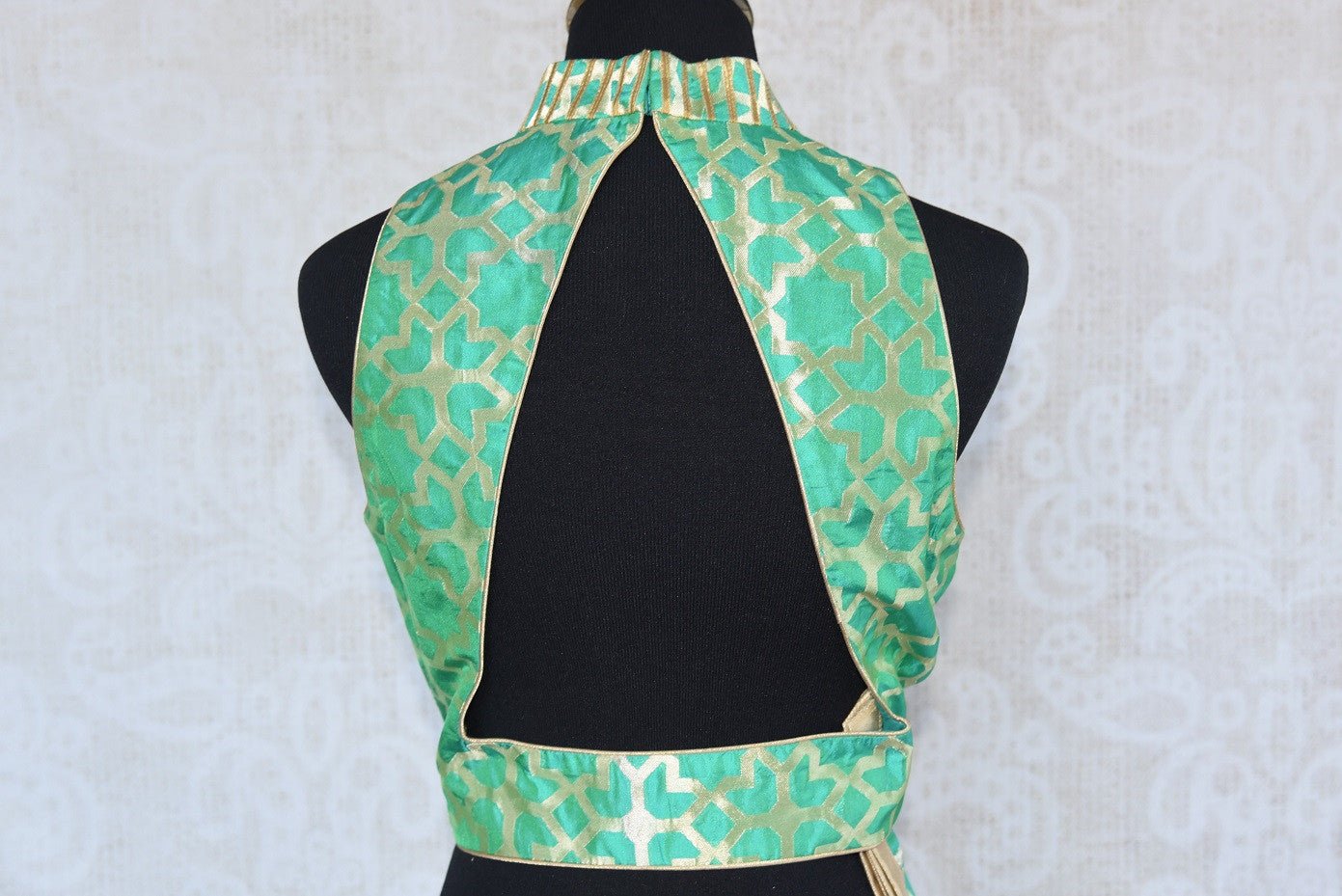 Buy this Indian traditional green halter neck sleeveless benarasi blouse from Pure Elegance online or from our store in USA. Perfect for any sangeet or reception. Back Slit.