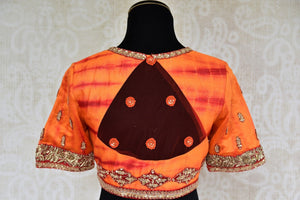 Buy designer raw silk tie and dye blouse online in orange color and embroidery. Pure Elegance brings Indian sari blouses online and in store for women in USA.-back