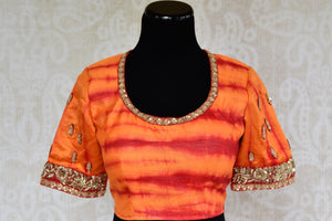 Buy designer raw silk tie and dye blouse online in orange color and embroidery. Pure Elegance brings Indian sari blouses online and in store for women in USA.-front