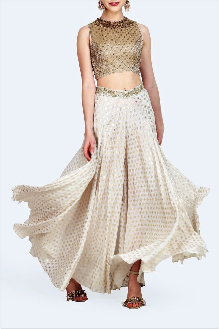 Buy gold brocade embroidered crop top with foil print sharara online in USA. For more such gorgeous designer dresses, shop at Pure Elegance Indian fashion store in USA. A beautiful range of traditional sarees and designer clothing is available for Indian women living in USA. You can also shop at our online store.-full view