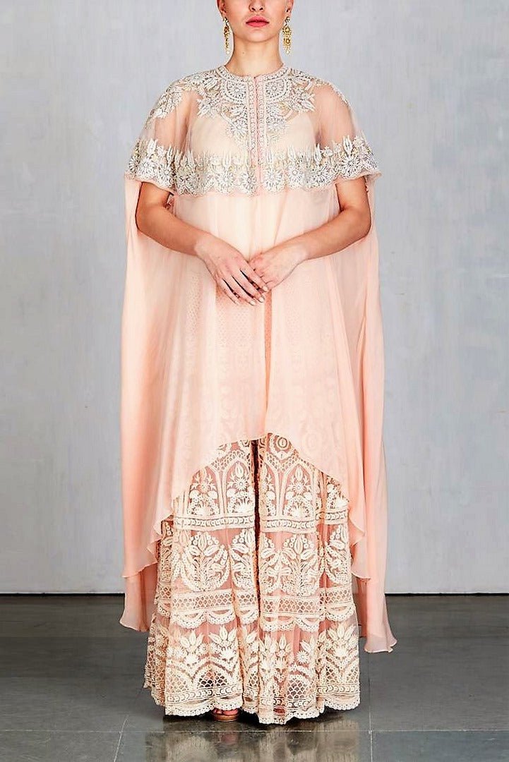 Shop designer peach color embroidered cape with sharara online in USA. Make a captivating fashion statement with a range of designer dresses from Pure Elegance clothing store in USA. If you are looking for Indian designer clothes online, then look to our online store for a stunning collection of Anarkali dresses, wedding lehengas and much more-full view