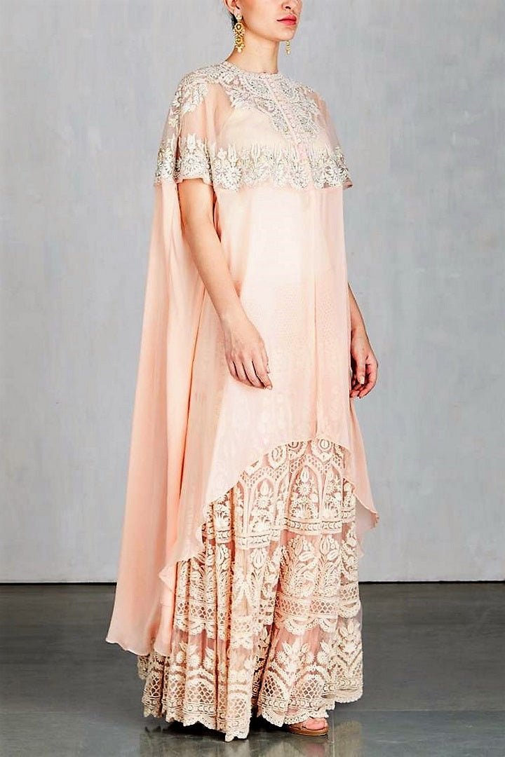 Shop designer peach color embroidered cape with sharara online in USA. Make a captivating fashion statement with a range of designer dresses from Pure Elegance clothing store in USA. If you are looking for Indian designer clothes online, then look to our online store for a stunning collection of Anarkali dresses, wedding lehengas and much more.-side