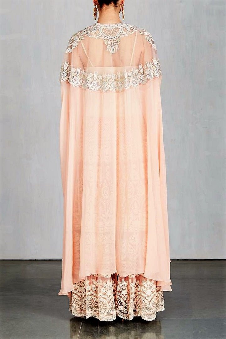 Shop designer peach color embroidered cape with sharara online in USA. Make a captivating fashion statement with a range of designer dresses from Pure Elegance clothing store in USA. If you are looking for Indian designer clothes online, then look to our online store for a stunning collection of Anarkali dresses, wedding lehengas and much more.-back