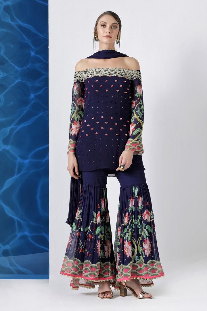 Buy navy embroidered off shoulder kurti with sharara and dupatta online in USA from Pure Elegance. Make your wardrobe an eclectic mix of alluring silhouettes and colors with a range of Indian designer clothing available at our clothing store in USA. -front