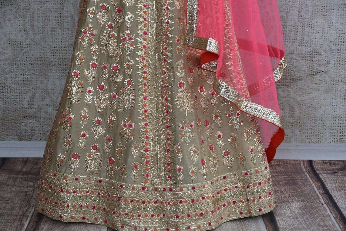 Beige fully embroidered designer anarkali suit comes with pink net dupatta . Perfect for wedding party and festivals.- gotta patti work