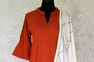 Buy rust orange linen kurta with white palazzo online in USA and dupatta from Pure Elegance Indian fashion store in USA. Make a stylish fashion statement this summer with a range of exquisite Indian designer dresses available online and at our clothing store in USA. Shop now.-front