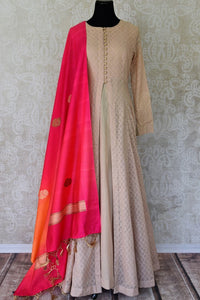 Sheer sophistication comes with muted tones and simplistic designs like this beige chanderi silk floor-length anarkali suit. The self-textured suit comes with a rich red silk dupatta to add oodles of charm. Shop designer salwar suits, lehenga sets, Indian dresses online or visit Pure Elegance store, USA.-full view