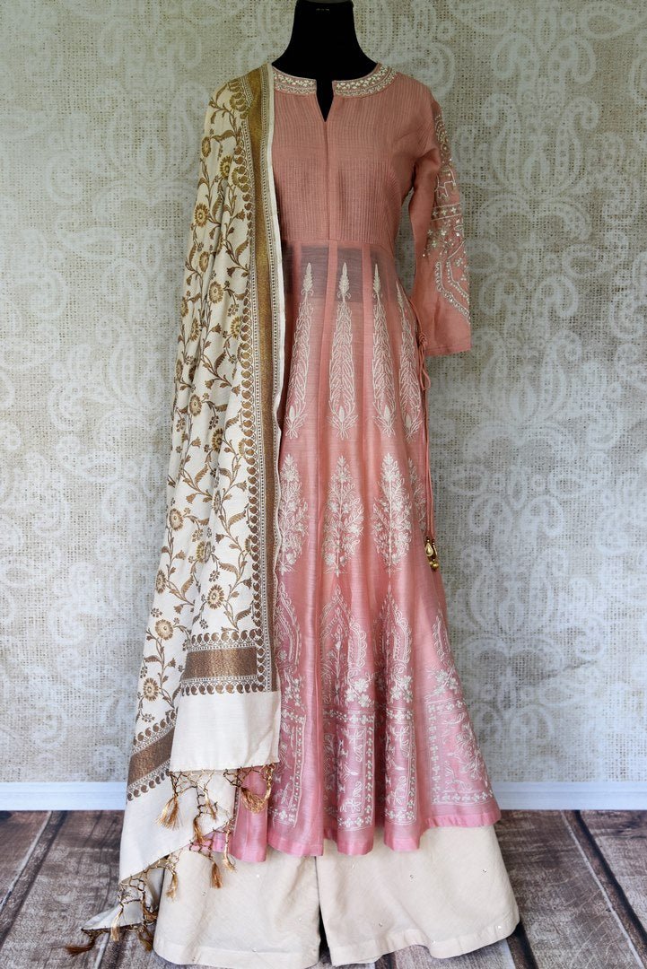 Sashay in breath-taking peach chanderi silk long kurta with an A-line structure. It comes with a complemented with a stunning cream floral muga silk dupatta. Style this outfit with a pair of white palazzo pants to add a dimension, Shop designer salwar suits, anarkali suits, lehenga sets online or visit Pure Elegance store, USA. -full view